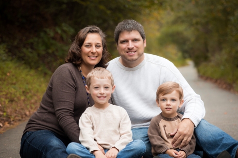 A family sits together on a blanket at White Deer Park for Christmas Card their annual photo.