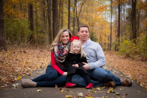 A family snuggles on a blanket wearing scarves for fall family portraits in Garner, NC.