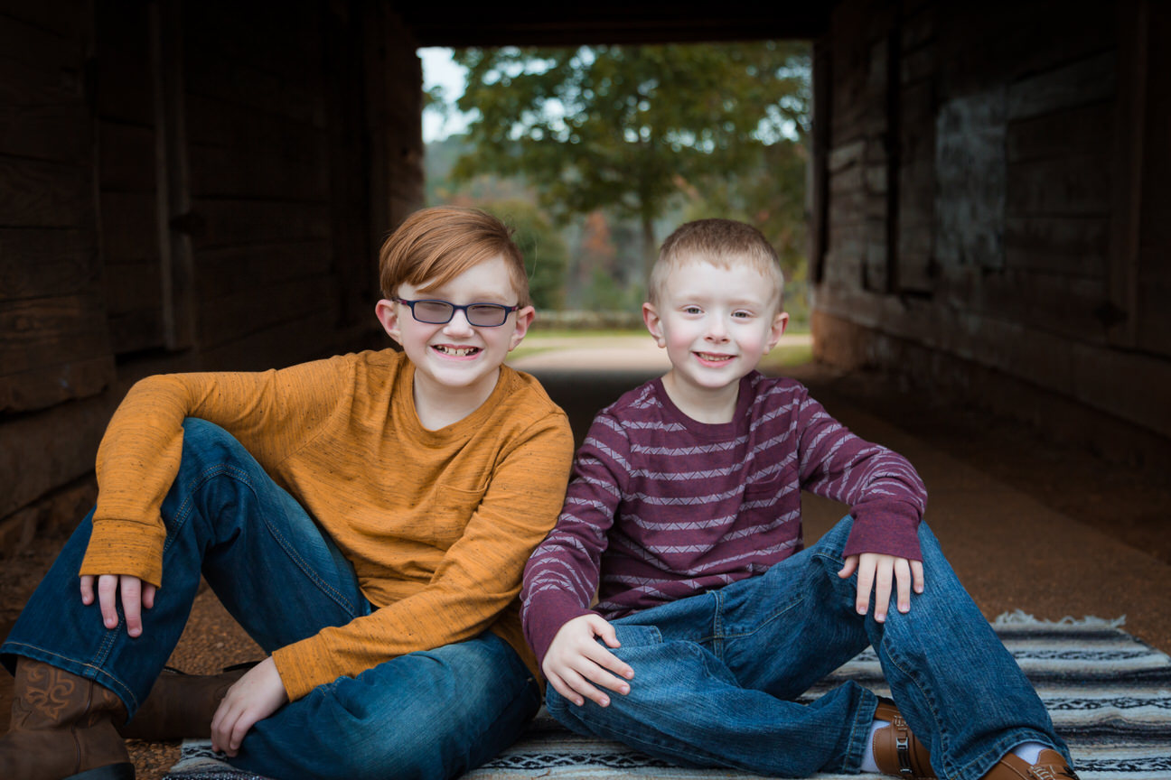 Two brothers sit on a blanket at Joyner Park in Wake Forest