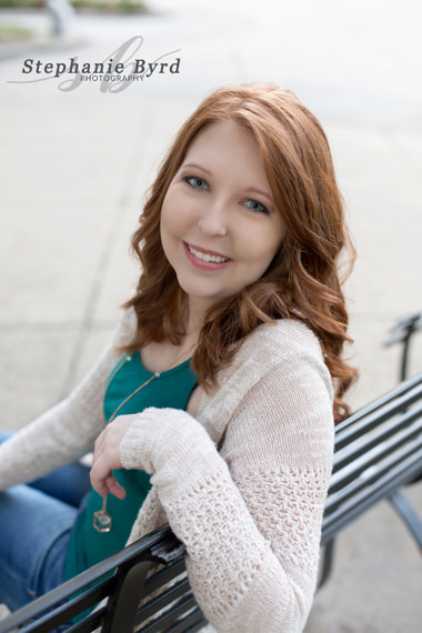 A young lady poses on a park bench outside the capital building in Raleigh, NC.