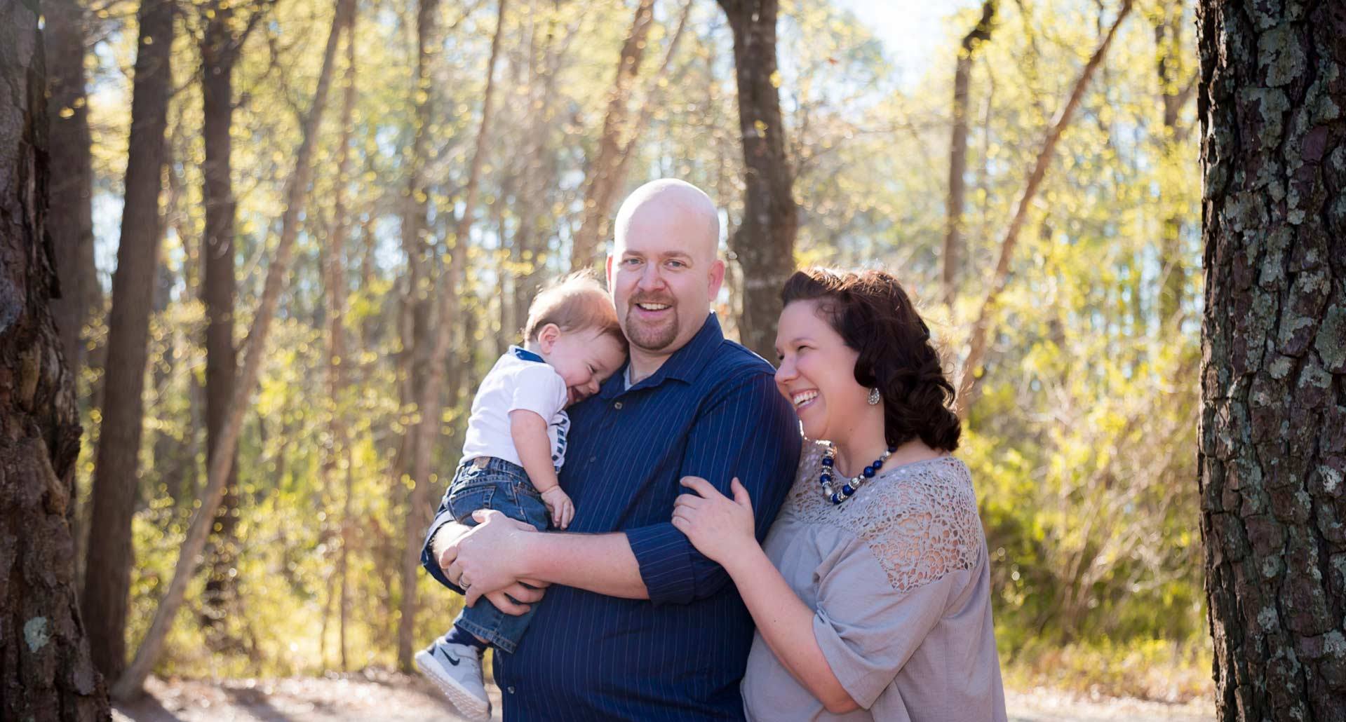 Family with children pose for a photo in a Raleigh NC park