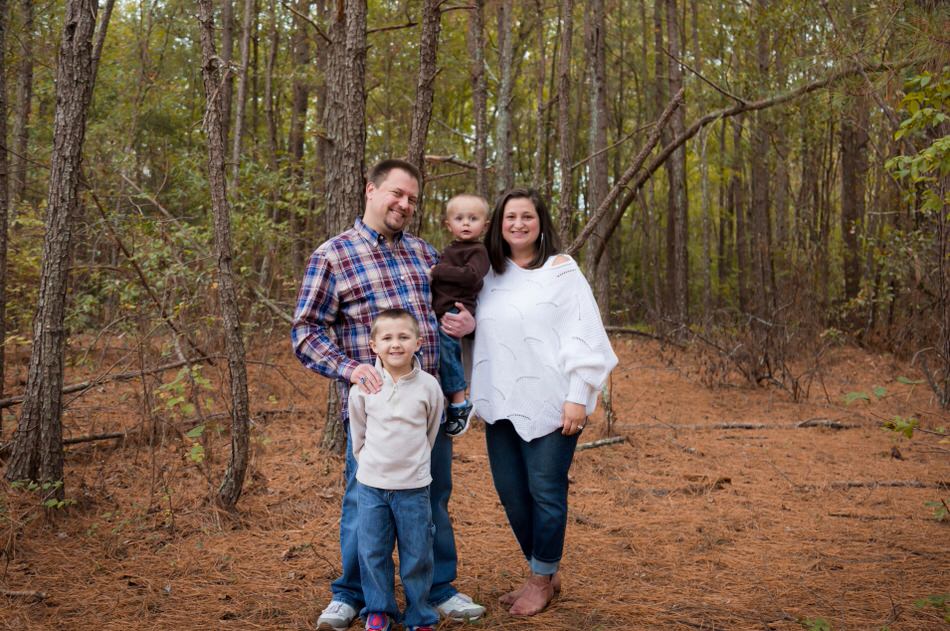 A family portrait with two children standing outside the Nature Center of White Deer Park in Garner, NC.