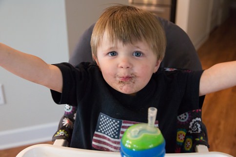 Child with messy face poses for family photo in Benson NC