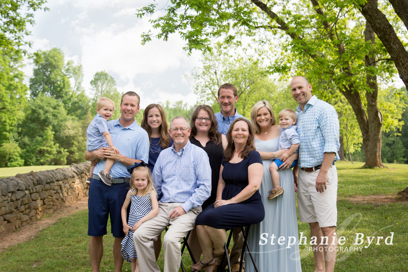 A large family with several generations gather for an outdoor photo in Joyner Park.