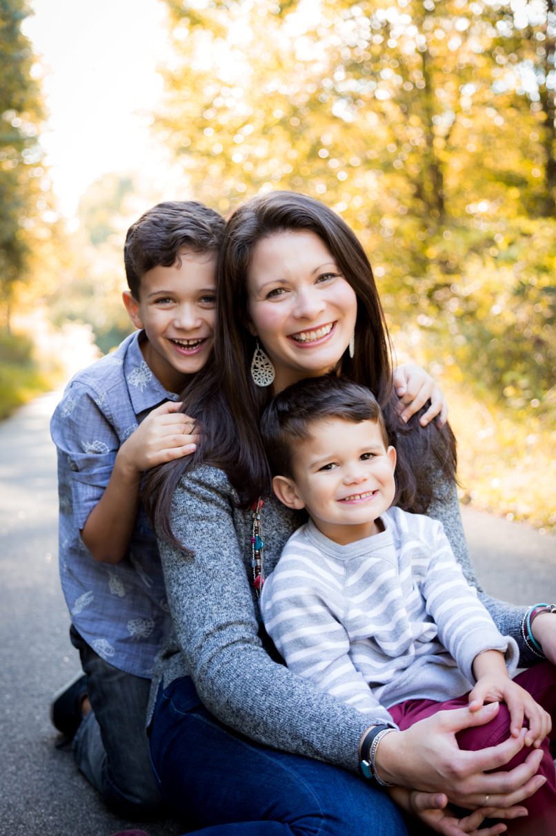 A mom sits with two boys for family photos in White Deer Park near Johnston and Wake Counties.